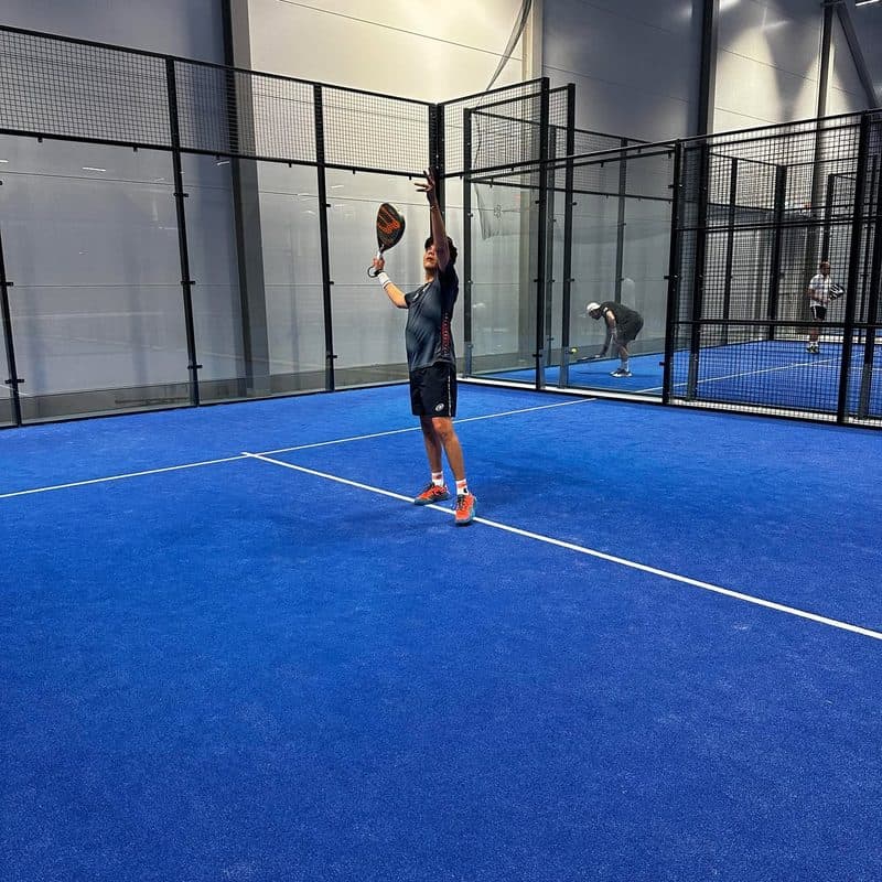 John playing padel on an indoor court